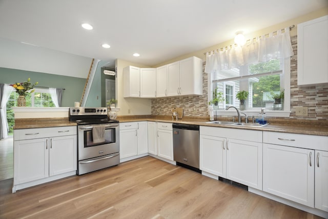 44 Emery Mills Rd, Lebanon, ME 04027 - kitchen featuring stainless steel appliances, a sink, backsplash, white cabinets, and light wood-style flooring