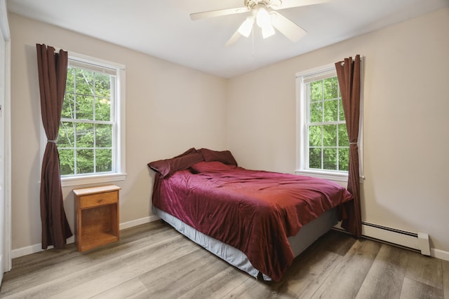 44 Emery Mills Rd, Lebanon, ME 04027 - bedroom featuring baseboard heating, wood finished floors, multiple windows, and baseboards