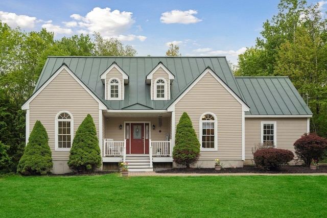 44 Emery Mills Rd, Lebanon, ME 04027 - cape cod house featuring a standing seam roof, covered porch, a front yard, and metal roof