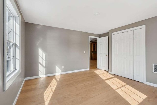 24 Cassella Dr, Jefferson, ME 04348 - unfurnished bedroom featuring light wood-type flooring, baseboards, and a closet