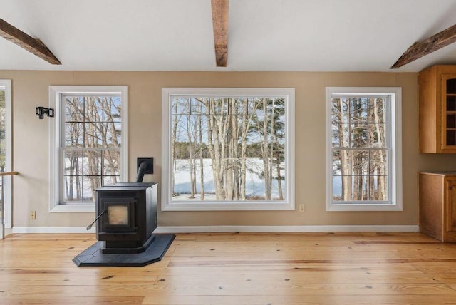 24 Cassella Dr, Jefferson, ME 04348 - unfurnished living room featuring light wood-type flooring, baseboards, and a wood stove