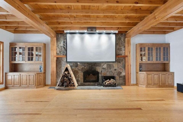 24 Cassella Dr, Jefferson, ME 04348 - unfurnished living room featuring wood ceiling with exposed beams, a stone fireplace, wood-type flooring, and baseboards