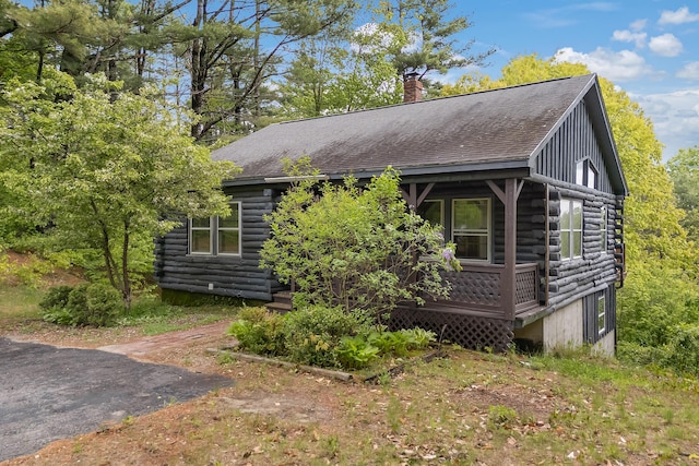 37 Boulder Dr, Auburn, ME 04210 - view of front of property featuring a chimney, roof with shingles, log exterior, and covered porch