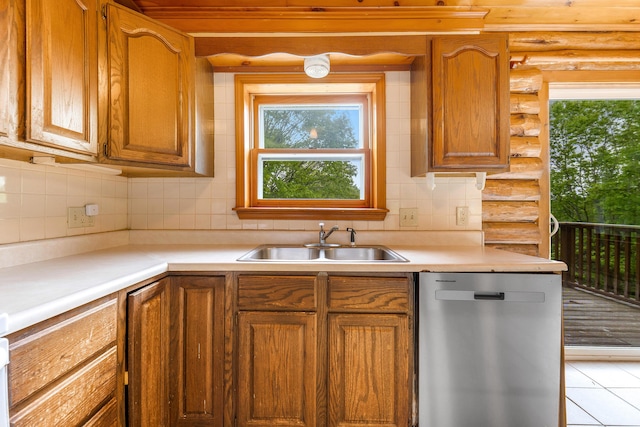 37 Boulder Dr, Auburn, ME 04210 - kitchen with stainless steel dishwasher, a sink, tasteful backsplash, light countertops, and rustic walls