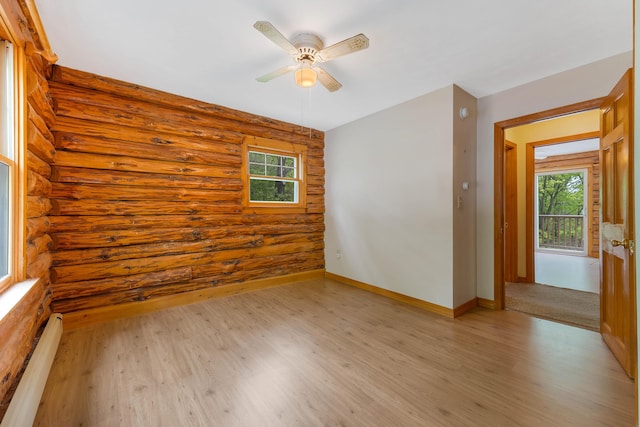 37 Boulder Dr, Auburn, ME 04210 - empty room with log walls, light wood-style floors, healthy amount of natural light, a baseboard heating unit, and a ceiling fan