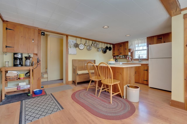 25 Church St, Gorham, ME 04038 - kitchen with freestanding refrigerator, light wood-style flooring, a breakfast bar area, and light countertops