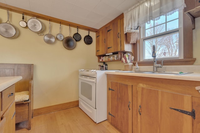 25 Church St, Gorham, ME 04038 - kitchen featuring white electric range oven, a sink, light wood-style flooring, light countertops, and brown cabinets