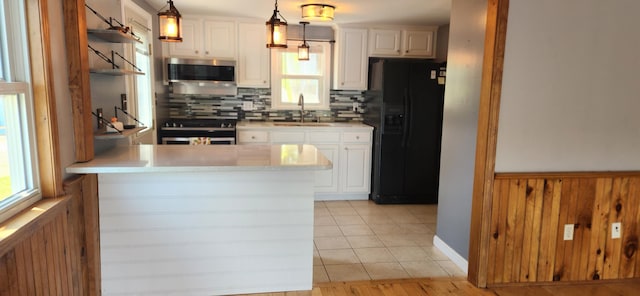 162 30th St, Shapleigh, ME 04076 - kitchen featuring black fridge, stainless steel microwave, stove, a peninsula, and tasteful backsplash