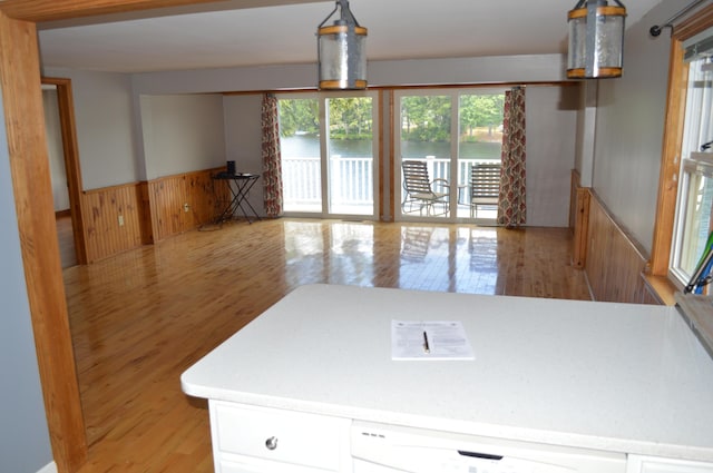 162 30th St, Shapleigh, ME 04076 - kitchen featuring light wood-style floors, wainscoting, white cabinetry, a water view, and wood walls