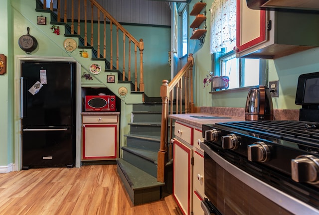 144 6th Ave, Madawaska, ME 04756 - kitchen with range with gas cooktop, freestanding refrigerator, light wood-style flooring, and extractor fan
