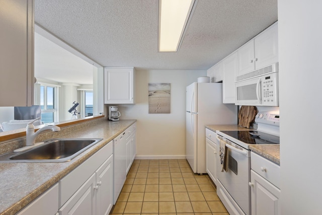 31 E Grand Ave Unit 80, Old Orchard Beach, ME 04064 - kitchen featuring white appliances, a sink, a textured ceiling, white cabinets, and light tile patterned floors
