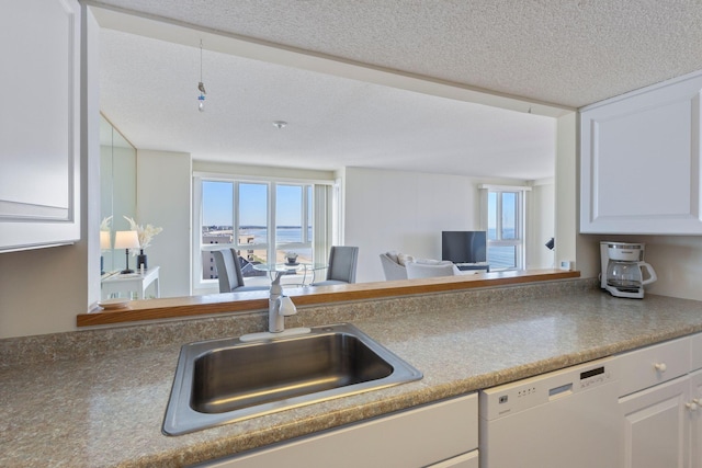 31 E Grand Ave Unit 80, Old Orchard Beach, ME 04064 - kitchen featuring dishwasher, a sink, white cabinetry, and a textured ceiling