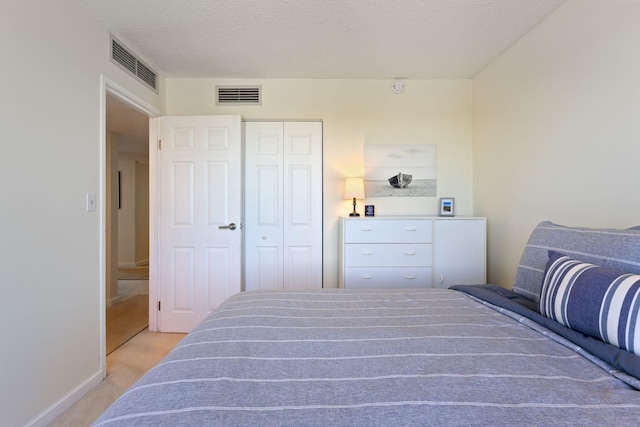 31 E Grand Ave Unit 80, Old Orchard Beach, ME 04064 - bedroom with light carpet, a closet, a textured ceiling, and baseboards