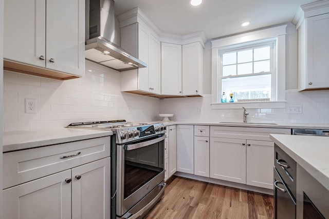 186 Falcon Crest Dr Unit 57, Gorham, ME 04038 - kitchen with stainless steel gas range oven, wall chimney range hood, a sink, light countertops, and white cabinets