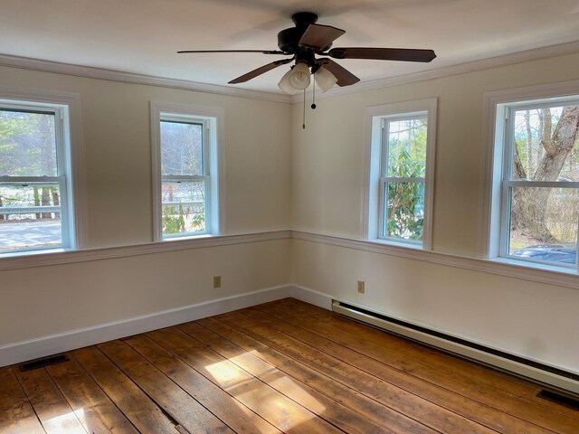 48 River Rd, Buxton, ME 04093 - empty room featuring baseboard heating, healthy amount of natural light, wood-type flooring, ornamental molding, and baseboards
