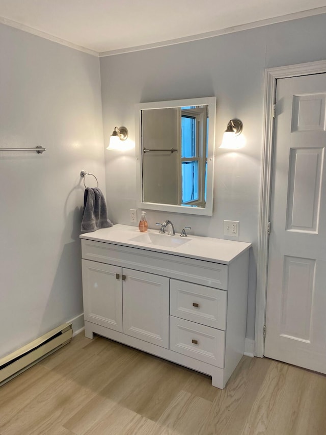 48 River Rd, Buxton, ME 04093 - bathroom with a baseboard heating unit, wood finished floors, vanity, baseboards, and ornamental molding