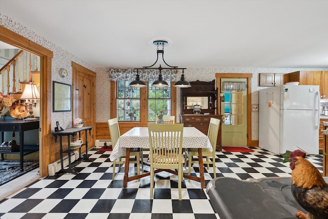 62 Blackswoods Rd, Franklin, ME 04634 - dining area featuring wallpapered walls, dark floors, wainscoting, baseboard heating, and stairway