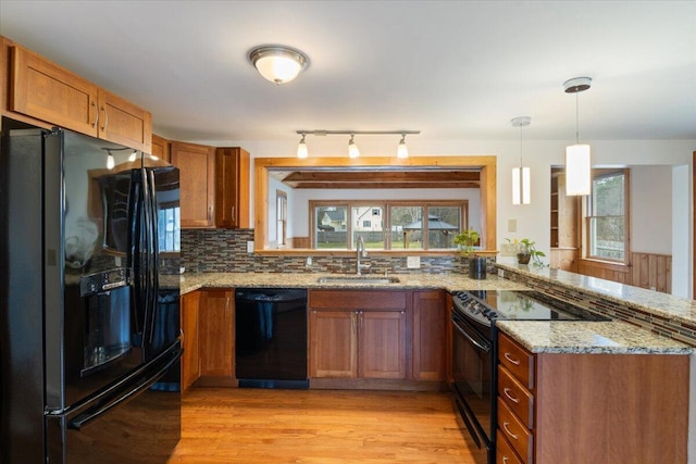 4 Buttonwood Rd, South Berwick, ME 03908 - kitchen with black appliances, a sink, a peninsula, brown cabinetry, and light wood-style floors