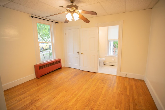 28 Pier St, Bangor, ME 04401 - unfurnished bedroom with radiator heating unit, light wood-style flooring, baseboards, a baseboard heating unit, and a drop ceiling