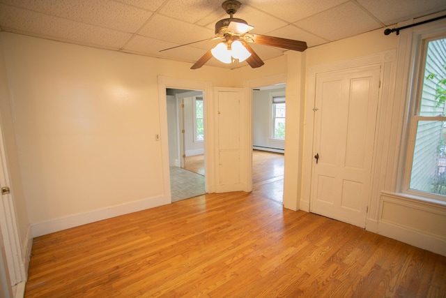 28 Pier St, Bangor, ME 04401 - unfurnished room featuring light wood-type flooring, a paneled ceiling, baseboards, a ceiling fan, and baseboard heating