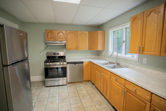 28 Pier St, Bangor, ME 04401 - kitchen with appliances with stainless steel finishes, under cabinet range hood, a sink, light countertops, and a paneled ceiling