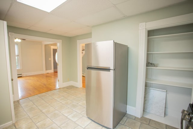 28 Pier St, Bangor, ME 04401 - kitchen featuring freestanding refrigerator, a drop ceiling, a baseboard radiator, and baseboards
