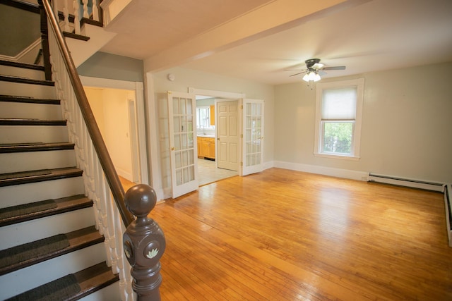28 Pier St, Bangor, ME 04401 - stairs with french doors, wood-type flooring, baseboard heating, a ceiling fan, and baseboards