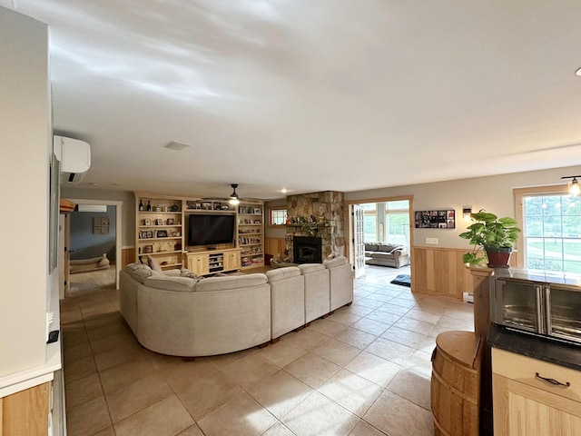 7 Ponderosa Ln, Biddeford, ME 04005 - living room with ceiling fan, a wainscoted wall, an AC wall unit, built in features, and a stone fireplace