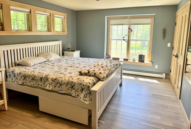 7 Ponderosa Ln, Biddeford, ME 04005 - bedroom with a baseboard heating unit, multiple windows, light wood-type flooring, and baseboards