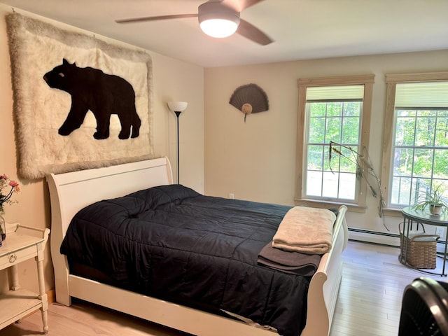 7 Ponderosa Ln, Biddeford, ME 04005 - bedroom with multiple windows, a baseboard heating unit, wood finished floors, and a ceiling fan