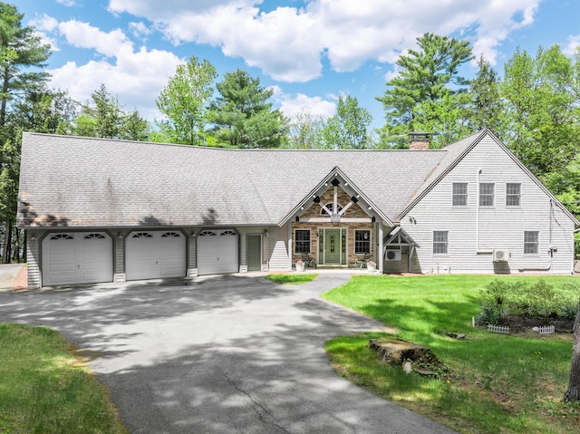129 Maple Shore Ln, Stetson, ME 04488 - view of front facade featuring a garage, asphalt driveway, a front lawn, a chimney, and roof with shingles