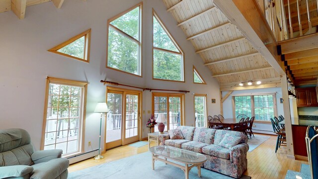 129 Maple Shore Ln, Stetson, ME 04488 - living room featuring high vaulted ceiling, light wood-type flooring, baseboard heating, wooden ceiling with exposed beams, and a baseboard heating unit