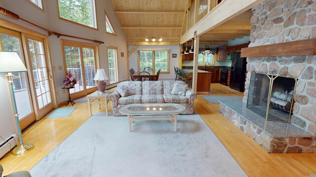 129 Maple Shore Ln, Stetson, ME 04488 - living area featuring light wood-type flooring, wood ceiling with exposed beams, high vaulted ceiling, a stone fireplace, and baseboard heating