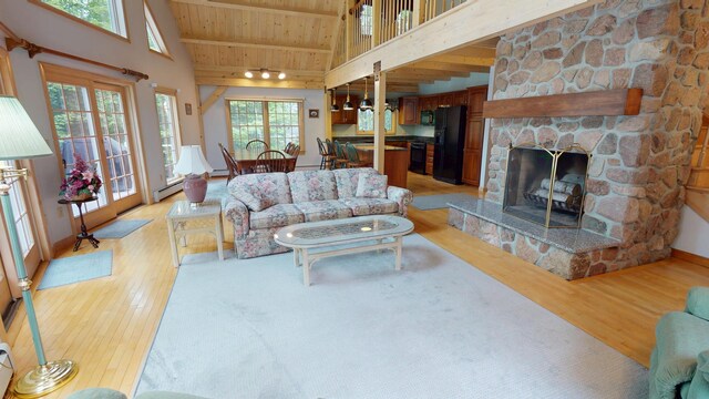129 Maple Shore Ln, Stetson, ME 04488 - living area featuring light wood-style floors, wooden ceiling with exposed beams, high vaulted ceiling, a fireplace, and baseboards