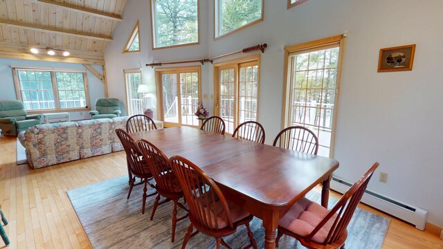 129 Maple Shore Ln, Stetson, ME 04488 - dining area with baseboard heating, wood ceiling with exposed beams, a high ceiling, and light wood-type flooring