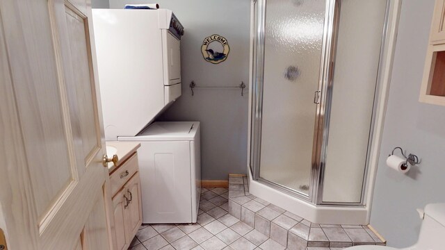 129 Maple Shore Ln, Stetson, ME 04488 - bathroom with a stall shower, stacked washer / drying machine, tile patterned floors, and toilet