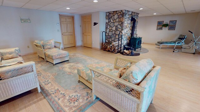 129 Maple Shore Ln, Stetson, ME 04488 - living area featuring a wood stove, a drop ceiling, wood finished floors, recessed lighting, and baseboards