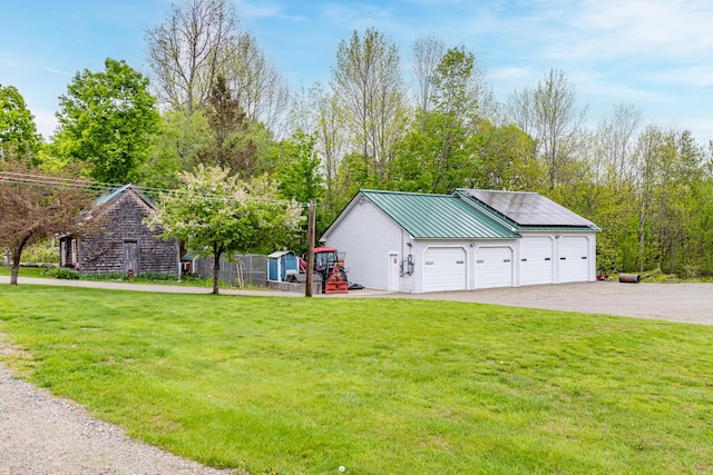303 Williams Rd, Bradford, ME 04410 - view of front facade featuring a front yard, a detached garage, an outdoor structure, asphalt driveway, and a metal roof