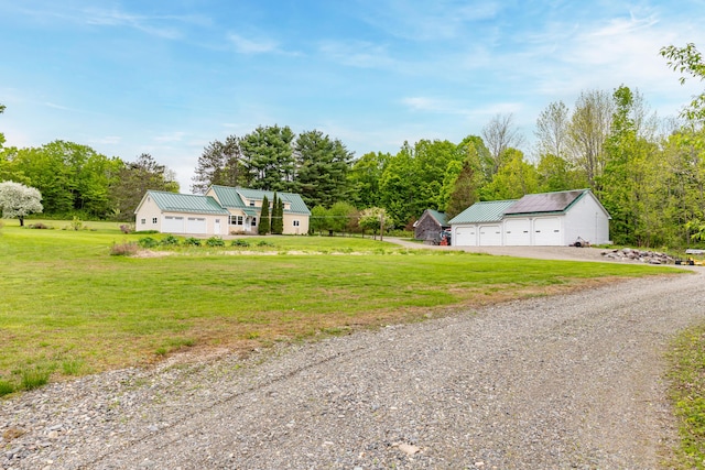 303 Williams Rd, Bradford, ME 04410 - view of front of home featuring a detached garage, a metal roof, a front yard, and an outdoor structure