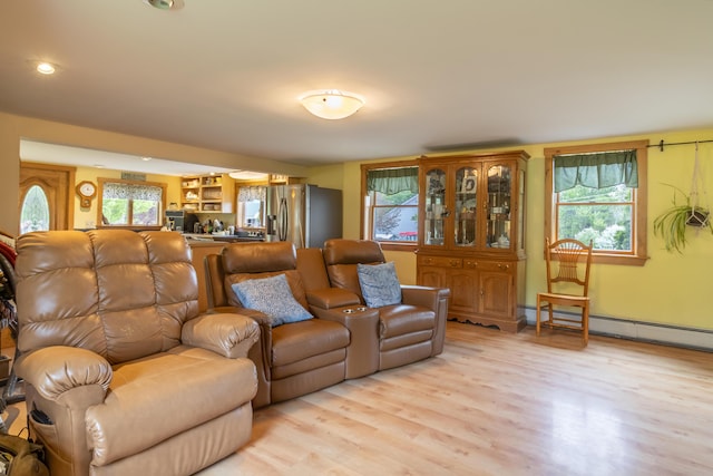 303 Williams Rd, Bradford, ME 04410 - living room with a baseboard heating unit, light wood-style floors, and plenty of natural light
