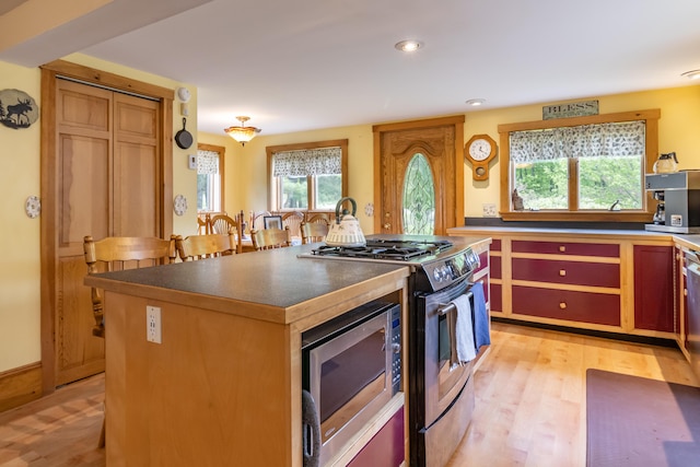 303 Williams Rd, Bradford, ME 04410 - kitchen with appliances with stainless steel finishes, light wood finished floors, a kitchen island, recessed lighting, and dark countertops