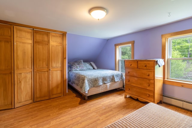 303 Williams Rd, Bradford, ME 04410 - bedroom with multiple windows, a baseboard radiator, light wood-type flooring, and lofted ceiling