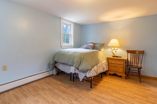 303 Williams Rd, Bradford, ME 04410 - bedroom featuring a baseboard heating unit and light wood-style flooring