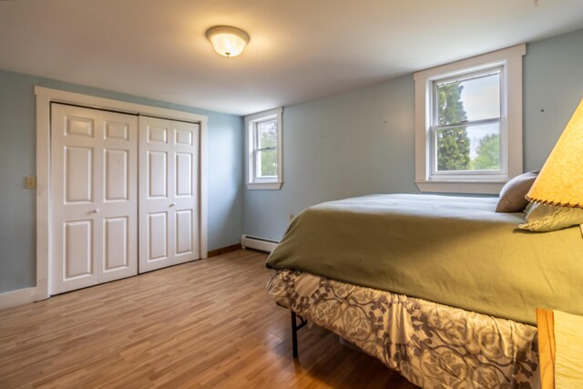 303 Williams Rd, Bradford, ME 04410 - bedroom with wood finished floors, a baseboard heating unit, and a closet