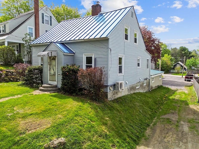 20 Donald St, Waterville, ME 04901 - view of front facade with a standing seam roof, a chimney, a front yard, metal roof, and a cooling unit