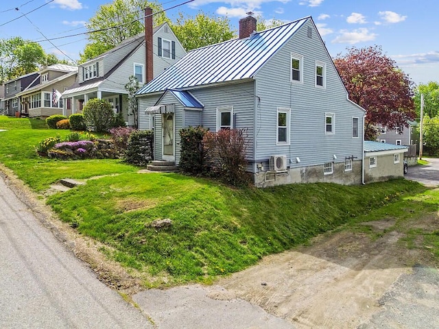 20 Donald St, Waterville, ME 04901 - view of front of home featuring a standing seam roof, a chimney, a front lawn, metal roof, and entry steps