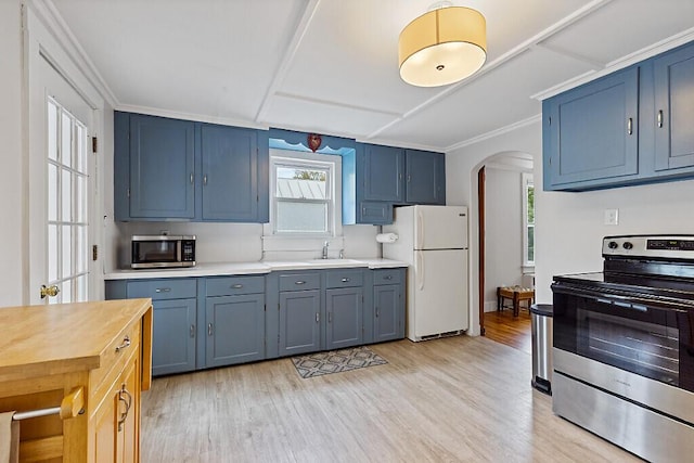 20 Donald St, Waterville, ME 04901 - kitchen featuring appliances with stainless steel finishes, arched walkways, a sink, light wood-style floors, and blue cabinets