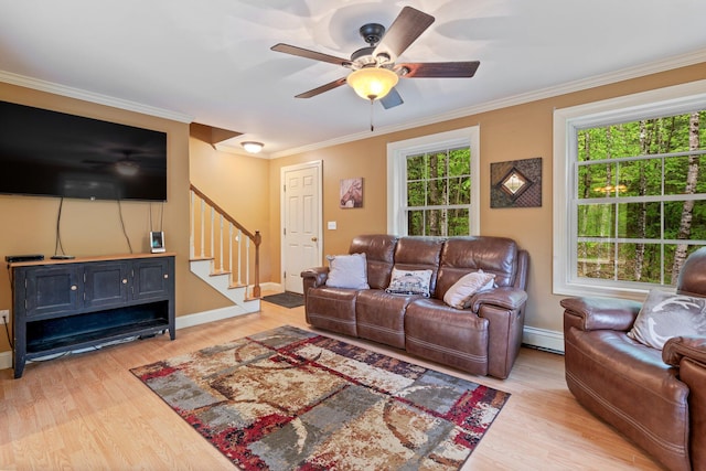 15 Convene Rd, Sebago, ME 04029 - living area with a baseboard heating unit, stairway, light wood-style flooring, ceiling fan, and crown molding