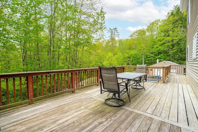 15 Convene Rd, Sebago, ME 04029 - wooden terrace with outdoor dining space and a view of trees