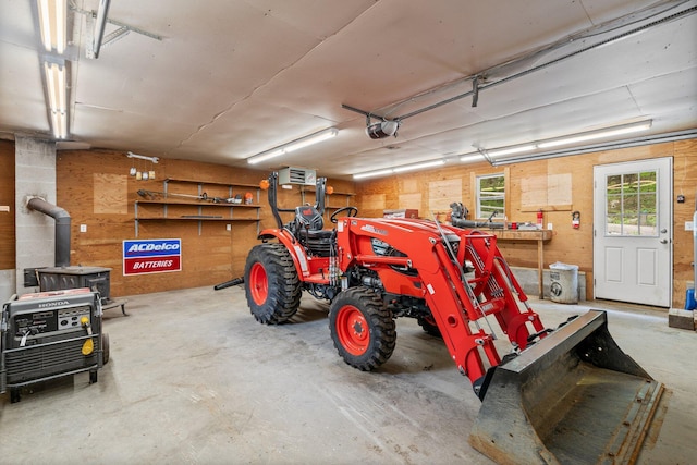 15 Convene Rd, Sebago, ME 04029 - garage with a garage door opener, a wood stove, and a workshop area